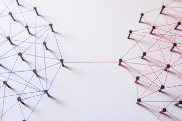 Connecting networks concept - two network connected with yarn red and blue on white paper. Simulator connection social media, internet, people communication