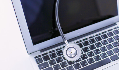 Wall Mural - Stethoscope lying on a laptop keyboard in a concept of online m