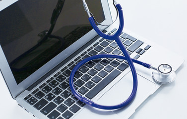 Stethoscope lying on a laptop keyboard in a concept of online m