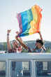 © ADDICTIVE STOCK - Gay couple in van holding LGBT flag