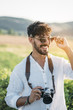 © ADDICTIVE STOCK - Cheerful man with photo camera in nature