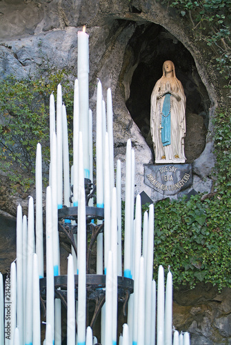 Cuadros en Lienzo Candles at the Grotto of Lourdes, in France, with the image of Bernadette in the