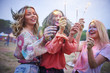 © Westend61 - Three women holding sparklers at music festival