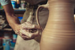 © master1305 - Creating a jar or vase of white clay close-up. Master crock. Man hands making clay jug macro.