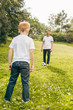 © LIGHTFIELD STUDIOS - father and son playing with soccer ball on green lawn in park