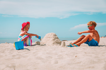 Poster - little girl and boy play with sand on beach