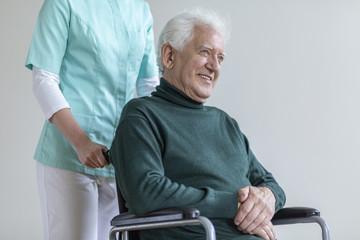 Canvas Print - Happy senior man in the wheelchair and nurse helping him