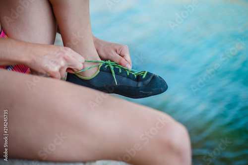 Fotografía Crop unrecognizable woman tying Feet of Cat rock climbing sneakers