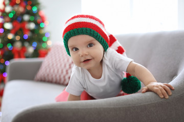 Wall Mural - Cute baby in Christmas costume on sofa at home