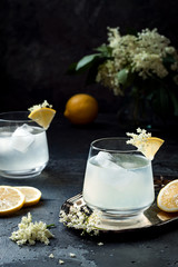 Wall Mural - Two glasses of homemade elderflower gin sour or lemonade garnished with freshly picked elderflowers.