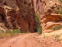 Red Dirt Road Through The Tall Canyons Of The Southern Utah Desert