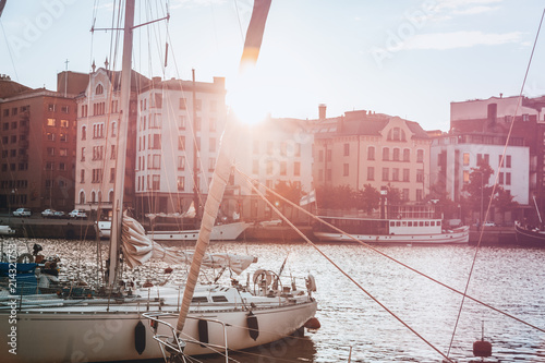 Cuadros en Lienzo A beautiful city landscape, a port with boats in the rays of the setting sun, He
