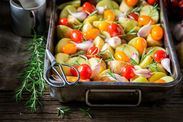 Wall Mural - Grilled potato with tomatoes and rosemary on old wooden table