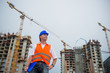© Marko Rupena - Proud architect smiling on a construction site with buildings and cranes in the background