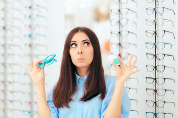 Woman Choosing Between Glasses and Contact Lenses in Optics Shop