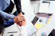 © Prathankarnpap - Top view Business team putting their hands together cooperation success business.
