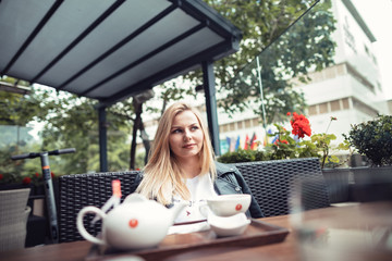 Woman having lunch in the first day of the summer dresses with a black jacket and a simplet white shirt talking with her friend.