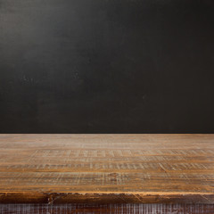 Wall Mural - Empty wooden table over chalkboard background