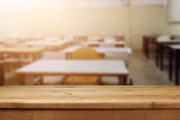 Empty wooden table over classroom background.
