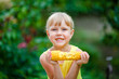© smile35 - The cheerful girl eats corn on a farm.