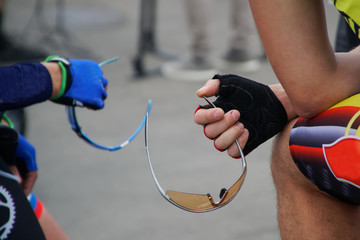 Active lifestyle. Two athletes - a cyclist holder of safety glasses before the start of the competition