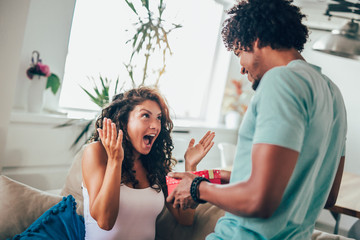 Wall Mural - Man giving a surprise gift to woman at home