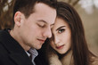 © sonyachny - stylish bride gently looking and groom embracing under  trees in winter forest. gorgeous wedding couple posing in winter snowy park. romantic sensual moment of newlyweds
