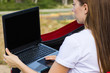© Egor - Girl using laptop outdoors, concept of modern technology