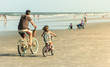 Father and Daughter Biking on Beach, Retro Look
