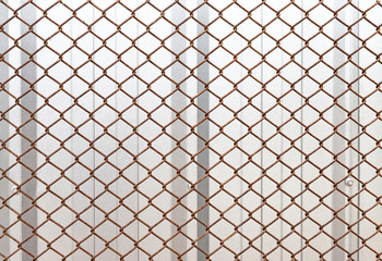 Closeup rusty steel mesh metal fence to protect house, construction concept, safety background