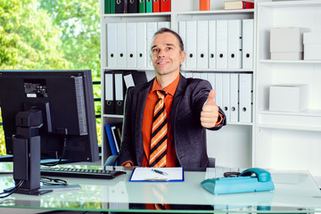 business man at his desk with thumb up