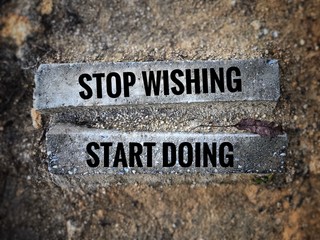 Wall Mural - Motivational and inspirational quote - ‘Stop wishing, start doing’ written on long bricks. Blurred vintage styled background.