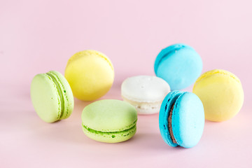 Wall Mural - Colorful Macarons Yellow Blue Green Macarons French Dessert Tasty Macarons Pink Background