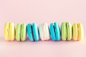 Wall Mural - Colorful Macarons Yellow Blue Green Macarons French Dessert Tasty Macarons Pink Background Toned