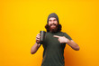 © Vulp - Happy bearded man pointing at mug cup of coffee to go
