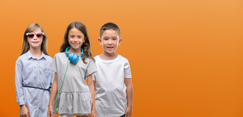 Sticker - Group of boy and girls kids over orange background with a happy face standing and smiling with a confident smile showing teeth