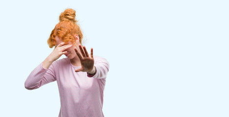 Poster - young redhead woman covering eyes with hands and doing stop gesture with sad and fear expression. em