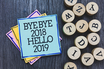 Canvas Print - Handwriting text Bye Bye 2018 Hello 2019. Concept meaning Starting new year Motivational message 2018 is over Black wooden deck written sticky note beside some round woody alphabets.