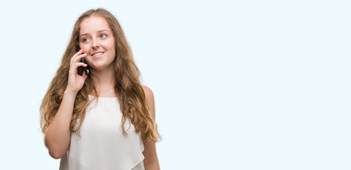 Wall Mural - Young blonde woman using smartphone with a happy face standing and smiling with a confident smile showing teeth