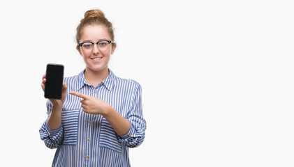 Poster - Young blonde woman using smartphone very happy pointing with hand and finger