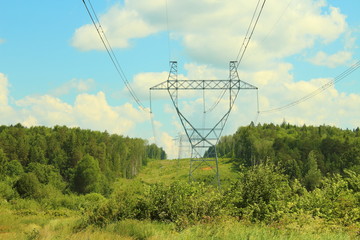 Metal poles of power lines. High-voltage direct current line. Power transmission towers. Close-up on nature.