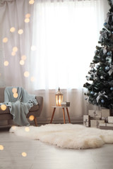 Wall Mural - Stylish living room interior with decorated Christmas tree and blurred lights in foreground