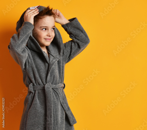 Cuadros en Lienzo Boy kid standing in gray bathrobe looking at the corner on yellow