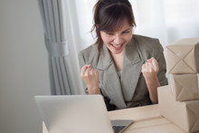 Excited Asian Woman Working With Her Laptop Computer And Courier Parcel Box; Portrait Of Excited, Happy Woman Business Owner With Business Success Or Profit Concept; Adult Asian Chinese Woman Model