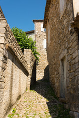 Long small cobbled alley between the houses in the old medieval village of Labeaume in France