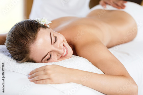Fotografering Beautiful woman lying on massage table and enjoying massage.