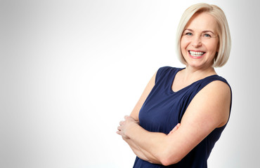 Wall Mural - attractive middle aged woman with folded arms on white background
