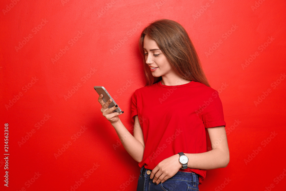 Beautiful young woman with mobile phone on color background
