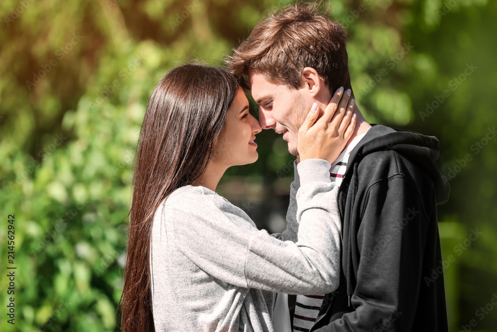 Happy young couple in green park on sunny spring day