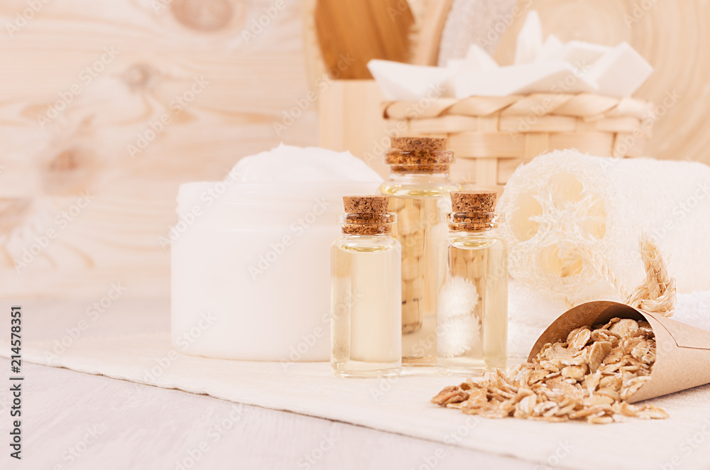 Rustic white homemade cosmetics set of natural products for body care and bath accessories with spikelets closeup in light beige wood interior, copy space.